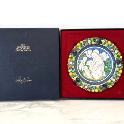 Sale Photo Thumbnail #332: The River Shore Della Robbia Annual Series collector plate by Roger J. Brown, featuring a bas-relief nativity scene with a colorful fruit and floral border, presented in its original velvet-lined display box.