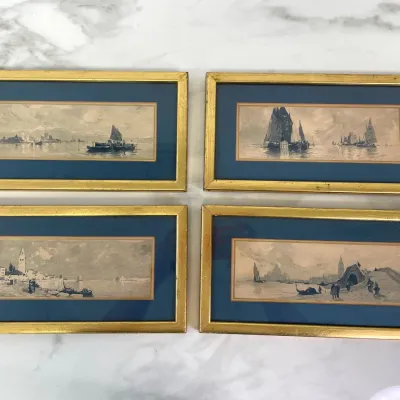 Sale Photo Thumbnail #29: Set of four vintage framed watercolor paintings depicting maritime and Venetian canal scenes, featuring blue matting and gilt wood frames.