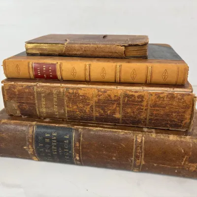 Sale Photo Thumbnail #203: Stack of four antique medical books with worn leather bindings, including "Gray's Anatomy Descriptive and Surgical", "Cooper's Lectures", and "Bell on the Hand".