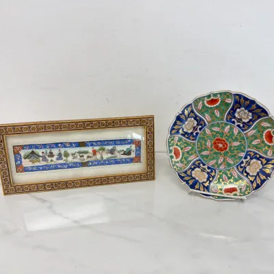 Sale Photo Thumbnail #257: Vintage Japanese Imari porcelain plate with scalloped edges alongside a framed Persian miniature painting on bone depicting a caravan scene.