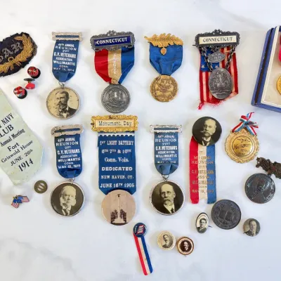 Sale Photo Thumbnail #306: Collection of antique Civil War veterans medals and ribbons, including Grand Army of the Republic (G.A.R.) reunion badges, Connecticut volunteer veterans medals, and historical ephemera dating from the early 1900s.