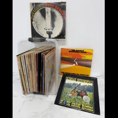 Sale Photo Thumbnail #91: Collection of vintage vinyl LP records, featuring albums by Pete Seeger, The Allman Brothers Band, and The Osborne Brothers, stored in a clear plastic bin.