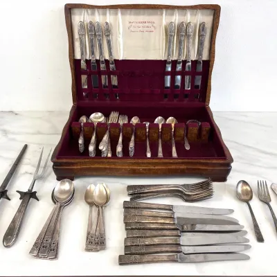 Sale Photo Thumbnail #20: Vintage 1847 Rogers Bros. silver-plated flatware set in a wooden storage chest with a tarnish-resistant lining, featuring an ornate floral pattern on the handles.