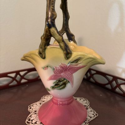 Hull pottery basket vase in the Water Lily pattern, featuring a pink and yellow gradient body with a branch-style handle, circa 1940s.