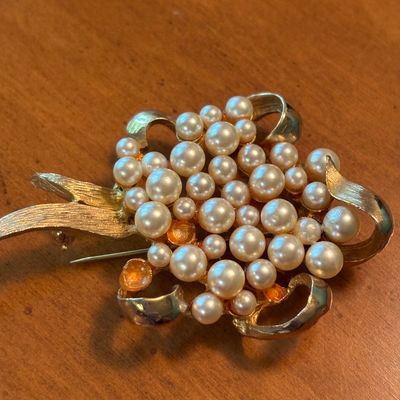 Vintage gold-tone floral brooch featuring a cluster of faux pearls in various sizes with textured leaf accents.