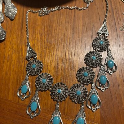 Vintage Southwestern-style silver-tone statement necklace featuring filigree flower links and dangling teardrop pendants set with faux...