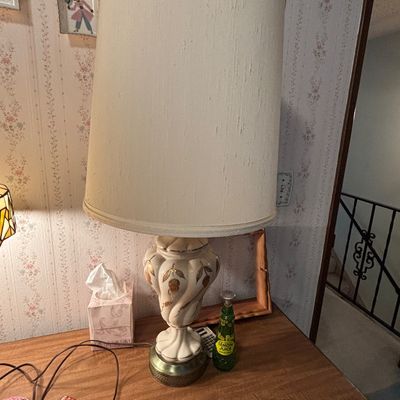 Vintage ceramic table lamp featuring a white and gold-gilt urn-style base with a tall, textured drum shade, circa 1960s.