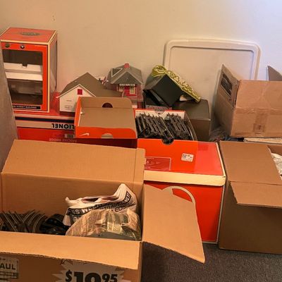 Collection of vintage Lionel model train accessories, including track pieces, buildings, and original boxes.