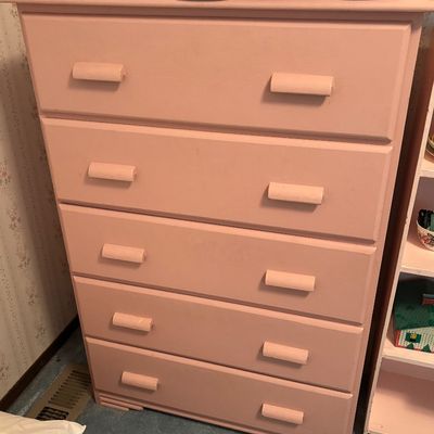 Vintage five-drawer wooden chest of drawers painted in a dusty pink finish, featuring matching wooden bar pulls and subtle Art Deco-style...