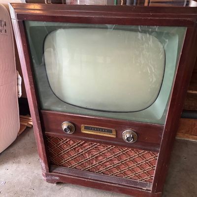 Vintage Crosley console television set in a dark wood cabinet, featuring original control knobs and a patterned speaker grille, circa 1950s.