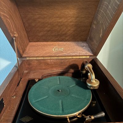 Antique Edison Disc Phonograph featuring a green felt turntable platter and brass reproducer arm, housed in a quarter-sawn oak cabinet,...