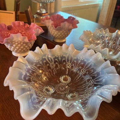 Fenton opalescent glass bowls, featuring a ruffled-edge hobnail bowl with pink interior and a clear-to-white opalescent patterned bowl.