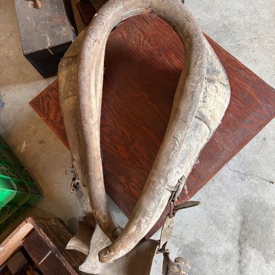 Vintage leather horse collar with heavy wear and weathering, suitable for rustic decor.
