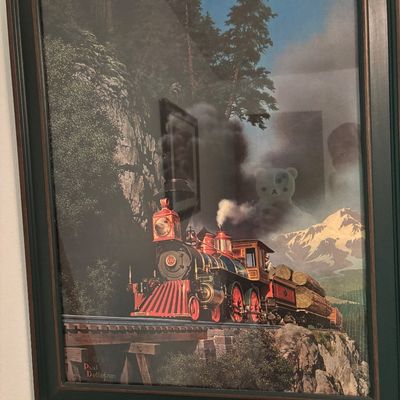 Framed print of a steam locomotive hauling logs across a mountain trestle, after an artwork by Paul Detlefsen, housed in a dark green and...