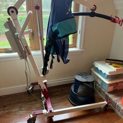 Sale Photo Thumbnail #113: BestLift electric patient lift with a 400 lb capacity, complete with a blue mesh transfer sling and rolling base.