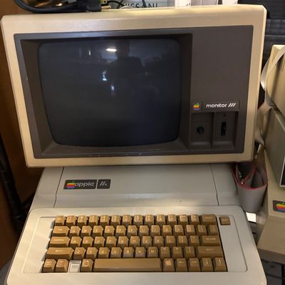 Vintage Apple IIe computer system with an Apple Monitor III, showing some age-related yellowing on the plastic casing.