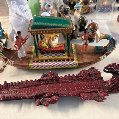Egyptian-themed decorative items, including a detailed model of Cleopatra's barge with figures and a red dragon-shaped incense burner.