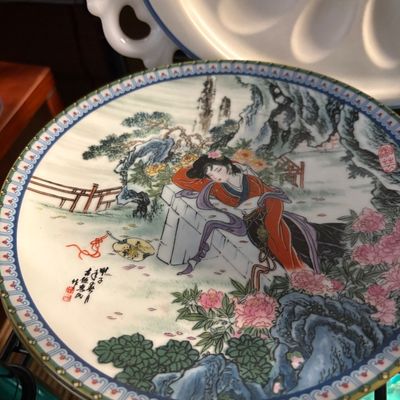 Vintage Chinese porcelain decorative plate featuring a hand-painted scene of a woman resting in a garden, complete with calligraphic...