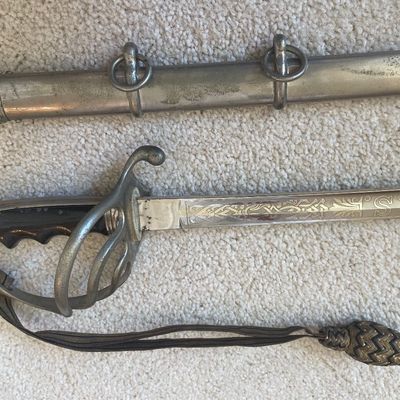Sale Photo Thumbnail #56: U.S. Model 1902 officer's sword with an etched steel blade, metallic guard, knot, and matching metal scabbard. Made by Henry V Allien, NY