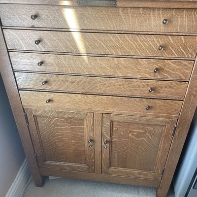 Sale Photo Thumbnail #53: Antique oak cabinet by The National Cash Register Co., featuring five wide shallow drawers over a double-door bottom storage compartment.