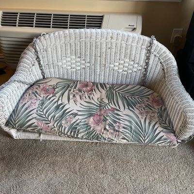 Sale Photo Thumbnail #17: White painted wicker porch swing featuring a high curved back, hanging chains, and a floral tropical print seat cushion.