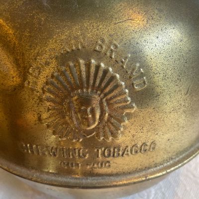 Sale Photo Thumbnail #51: Vintage brass spittoon featuring embossed Red Man Brand Chewing Tobacco logo with Native American chief profile.