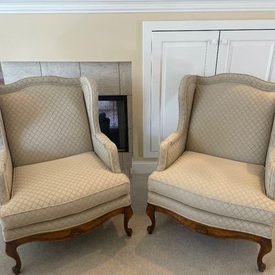Sale Photo Thumbnail #3: Pair of French Provincial style wingback armchairs upholstered in a neutral diamond lattice patterned fabric with carved wooden frames.