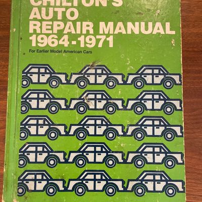 Sale Photo Thumbnail #77: Vintage Chilton's Auto Repair Manual covering 1964-1971 American cars, featuring a green hardcover with graphic car motifs and showing light exterior wear.