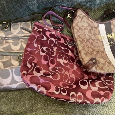 Sale Photo Thumbnail #186: Trio of Coach signature Jacquard canvas handbags, including a brown shoulder bag with stripe detail, a burgundy tote, and a grey/taupe satchel.