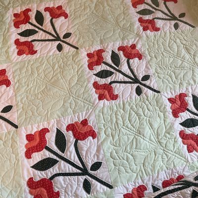 Sale Photo Thumbnail #204: Handmade appliquéd quilt featuring red floral motif blocks alternating with pale green intricate feathered quilting blocks. Hand quilted. 