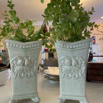 Sale Photo Thumbnail #91: Pair of vintage light green crackle-glazed ceramic vases featuring embossed cherub motifs and small scroll feet