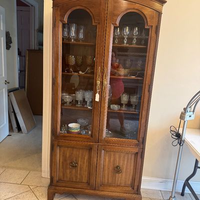 Sale Photo Thumbnail #163: Traditional wooden china cabinet with arched glass doors, brass hardware, and lower storage cabinet