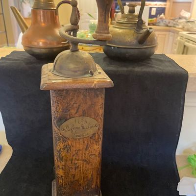 Sale Photo Thumbnail #73: Vintage Italian wooden manual coffee grinder labeled "Stefano Ugolini Firenze," accompanied by two brass and copper teakettles.