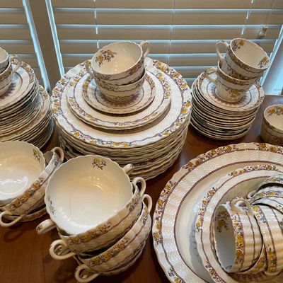 Sale Photo Thumbnail #166: Large vintage Spode china service set in a yellow and brown floral pattern, including plates, teacups, saucers, and double-handled soup bowls.