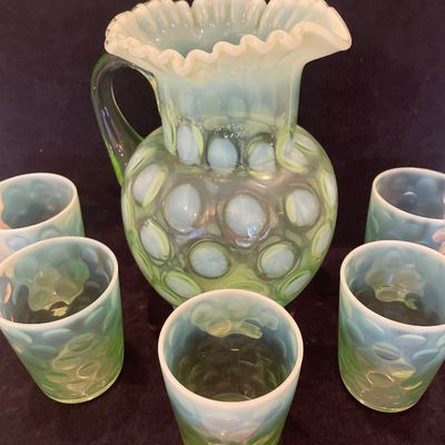 Sale Photo Thumbnail #61: Fenton or Northwood green opalescent coin dot pitcher set, complete with five matching drinking glasses featuring a ruffled rim pitcher.