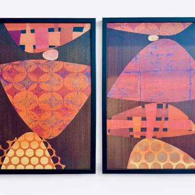 Sale Photo Thumbnail #48: Pair of mid-century modern style abstract prints featuring stacked geometric shapes in warm orange, pink, and brown tones, presented in simple black frames.