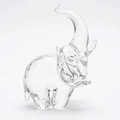 Sale Photo Thumbnail #27: Swarovski crystal elephant figurine with its trunk raised, featuring a faceted body and smooth head, in excellent condition.