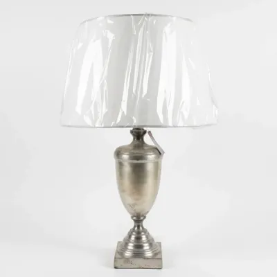 Sale Photo Thumbnail #51: Neoclassical-style silver-toned metal urn table lamp with a square pedestal base and a white drum shade still in its protective plastic wrap.