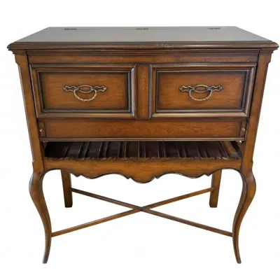 Sale Photo Thumbnail #42: Vintage French Provincial style wooden dry bar cabinet, featuring a flip-top surface, two drawers with ornate brass pulls, a lower bottle rack, and elegant cabriole legs with an X-stretcher.