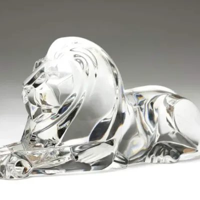 Sale Photo Thumbnail #41: Baccarat clear crystal reclining lion figurine, featuring a stylized, polished design with a textured mane.