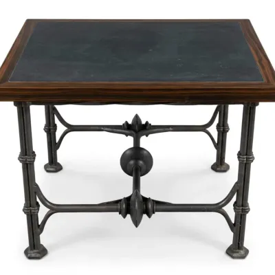 Sale Photo Thumbnail #26: Industrial-style side table featuring a dark stone or slate top inset within a rich wood frame, supported by an ornate wrought iron base with decorative stretchers.