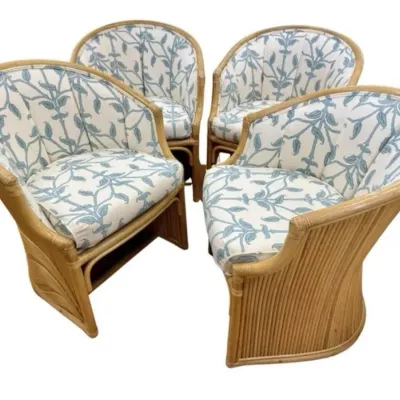 Sale Photo Thumbnail #75: Set of four vintage rattan barrel chairs featuring split-reed bases and upholstered cushions with a blue and white botanical pattern.