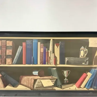 Sale Photo Thumbnail #65: Trompe l'oeil style framed print depicting a bookshelf filled with vintage books, a stein, and a trophy, housed in a simple black frame.