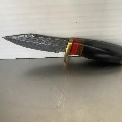 Sale Photo Thumbnail #23: Custom fixed-blade knife featuring a Damascus steel blade, brass guard, and a multi-material handle with wood and black horn or synthetic spacers.