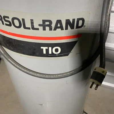 Sale Photo Thumbnail #13: Ingersoll Rand T10 vertical air compressor tank with power cord and plug, showing some surface wear from use.