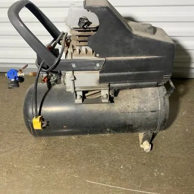 Sale Photo Thumbnail #5: Portable electric air compressor with a horizontal black tank, showing some dust and wear from use.