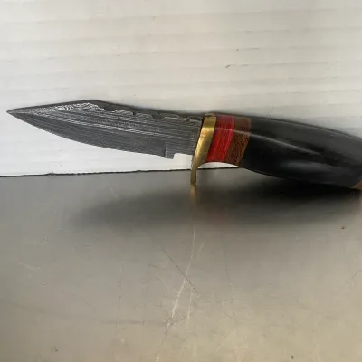 Sale Photo Thumbnail #58: Custom fixed-blade knife featuring a Damascus steel blade, brass guard, and a multi-material handle with wood, red spacers, and a dark horn or synthetic grip.