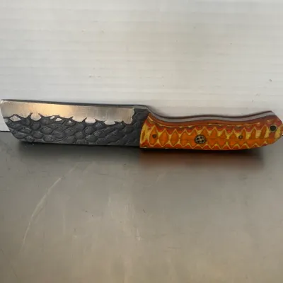 Sale Photo Thumbnail #54: Custom fixed-blade knife featuring a textured, scale-patterned blade and a vibrant orange and yellow layered G10 handle with a mosaic pin.