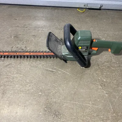 Sale Photo Thumbnail #9: Black & Decker Auto Stop electric hedge trimmer with an 18-inch blade, showing some wear from use.