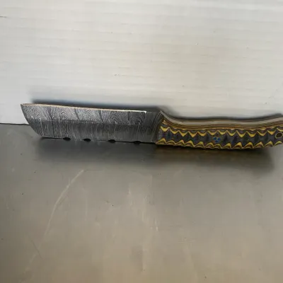 Sale Photo Thumbnail #49: Custom Damascus steel cleaver-style knife featuring a patterned blade and a textured, multi-colored composite handle.